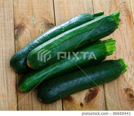 Zucchinis on wooden background 86688441