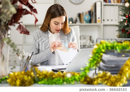 Woman receiving money at office during Christmas 86688583