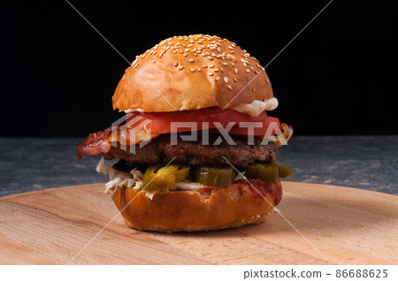Burger with beef, bacon and jalapeno on a black background 86688625
