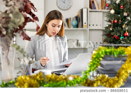 Tired business woman working with documents in business office during christmas Tired business woman working with documents in business office during christmas 86688651