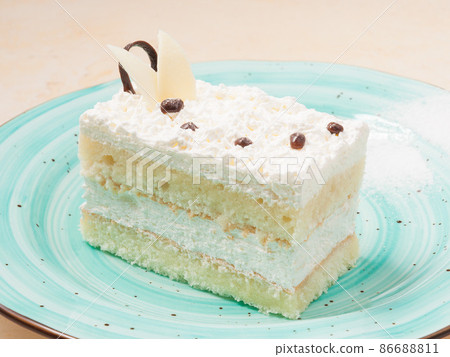 slice of coconut sponge cake with cream 86688811
