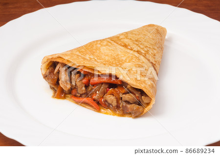 crepe with chicken and vegetables on a white plate crepe with chicken and vegetables on a white plate 86689234