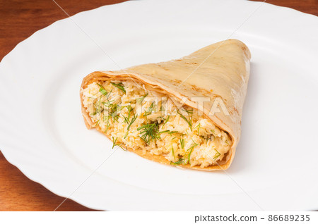 crepe with cheese, garlic and herbs on a white plate crepe with cheese, garlic and herbs on a white plate 86689235