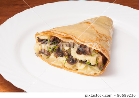 crepe with potatoes and mushrooms on a white plate crepe with potatoes and mushrooms on a white plate 86689236
