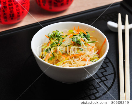cellophane with vegetables in a white bowl and a black background cellophane with vegetables in a white bowl and a black background 86689249