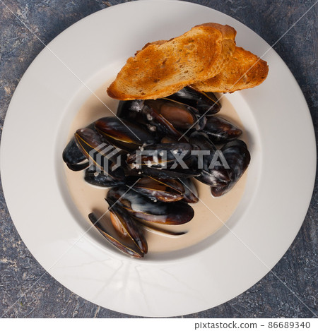 mussels in cream sauce with baguette. Top view mussels in cream sauce with baguette. Top view 86689340