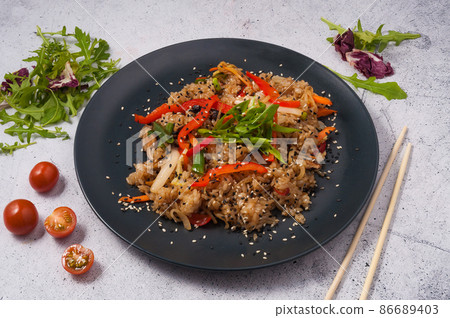 fried rice with vegetables on a black plate. Asian cuisine 86689403