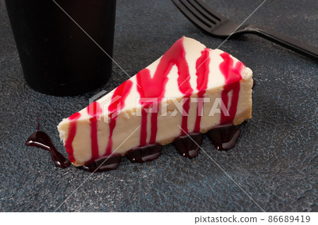 cheesecake with berry sauce on a dark background cheesecake with berry sauce on a dark background 86689419