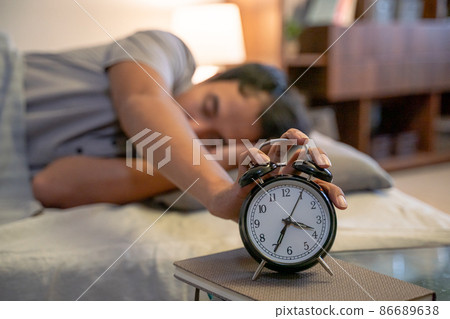 muslim man in the bed turning the alarm off muslim man in the bed turning the alarm off 86689638