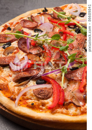 pizza with bacon and hunting sausages on a gray background. close up 86689841