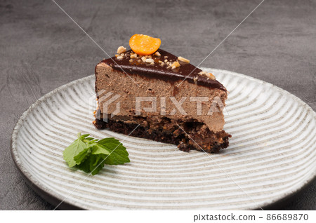 a piece of cake with chocolate mousse decorated with physalis and mint 86689870