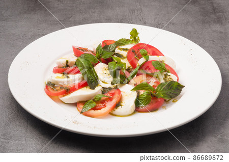 Caprese salad with tomatoes and mozzarella on a white plate Caprese salad with tomatoes and mozzarella on a white plate 86689872