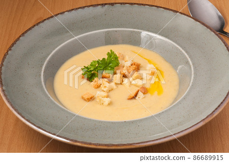 mashed soup with croutons decorated with herbs. close up 86689915