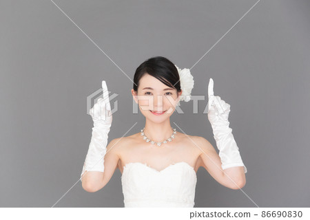 一個穿著婚紗的女人用手指指著 一個穿著婚紗的女人用手指指著 86690830