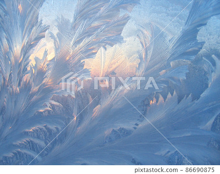 Ice pattern and sunlight closeup on window glass early in the morning Ice pattern and sunlight closeup on window glass early in the morning 86690875