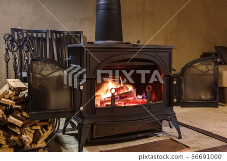 burning wood in the stove in a country house 86691000