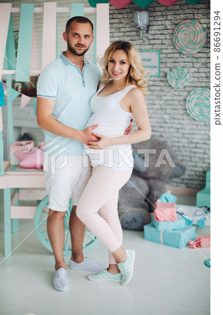 Handsome husband and pragnant woman posing at 86691294