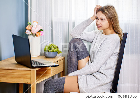 Live streaming virtual classes on laptop during coronavirus lockdown for woman indoors. Live streaming virtual classes on laptop during coronavirus lockdown for woman indoors. 86691310