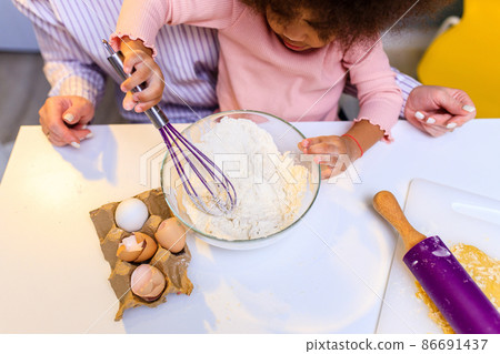 happy multiethnic family cooking pastry together at kitchen 86691437