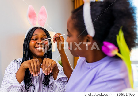 two polyethnic pretty woman having fun and preparing to easter together two polyethnic pretty woman having fun and preparing to easter together 86691460