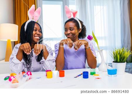 two polyethnic pretty woman having fun and preparing to easter together 86691480