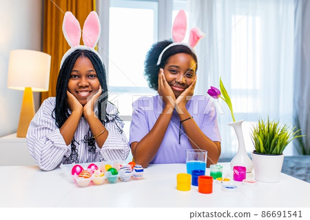 two polyethnic pretty woman having fun and preparing to easter together 86691541