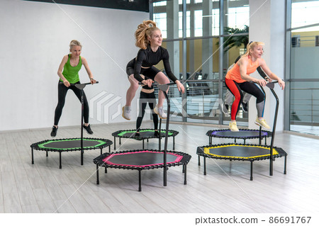 Trampoline for fitness girls are engaged in professional sports, the concept of a healthy lifestyle jumping trampoline woman fitness gym healthy, for workout active for cardio and fun athlete, young Trampoline for fitness girls are engaged in professional sports, the concept of a healthy lifestyle jumping trampoline woman fitness gym healthy, for workout active for cardio and fun athlete, young 86691767