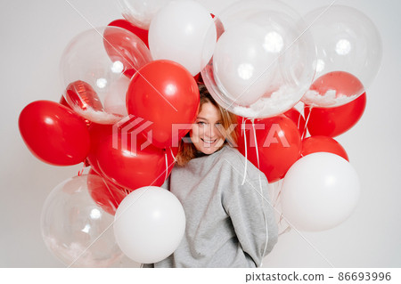 an blonde woman with balloons on a white background. valentine's day an blonde woman with balloons on a white background. valentine's day 86693996