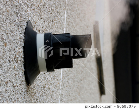Central Heating Boiler Vent with Steam on an External House Wall 86695079