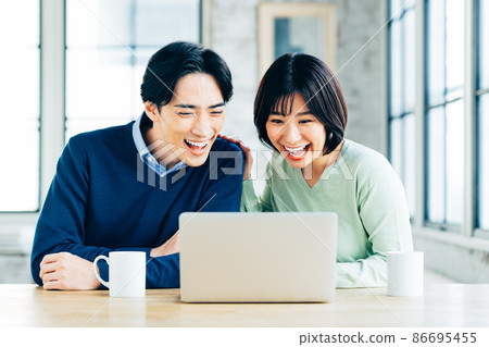 一對年輕夫婦正在看電腦 86695455