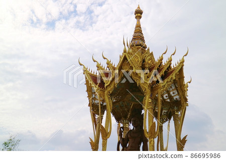 In the sky with blue sky and white clouds, there is a temple made of gilded gold, a tower made of ornate carvings 86695986