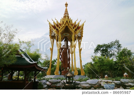 There is a huge golden temple in the woods and a Buddha statue in the middle 86695987