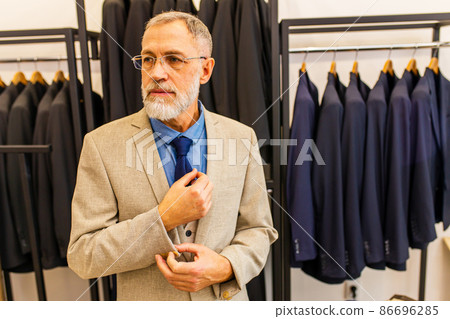 elderly good looking man in stylish and rich suit owner of atelier studio busy with work 86696285