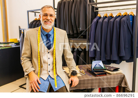 mature tailor working with sewing pattern in atelier mature tailor working with sewing pattern in atelier 86696291