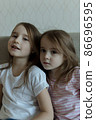 Two younger sisters are playing on the couch. Cozy home communication 86696595