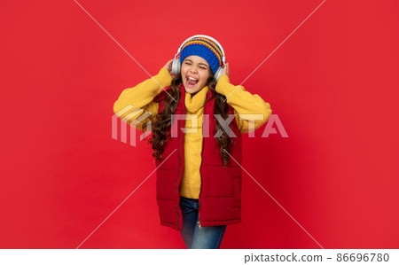 express positive emotion. winter fashion. teen girl in hat and earphones. express positive emotion. winter fashion. teen girl in hat and earphones. 86696780