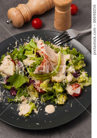 Caesar salad in an alternative modern serving on a black plate Caesar salad in an alternative modern serving on a black plate 86698056