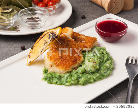 breaded fish fillet with spinach puree garnish breaded fish fillet with spinach puree garnish 86698085