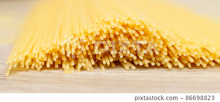 spaghetti yellow background close. raw pasta macro spaghetti yellow background close. raw pasta macro 86698823