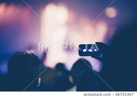 Fan taking photo of concert with a mobile phone 86701467