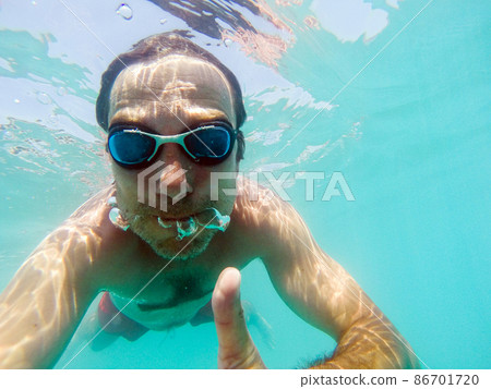 Underwater view of a man swimming in the sea Underwater view of a man swimming in the sea 86701720