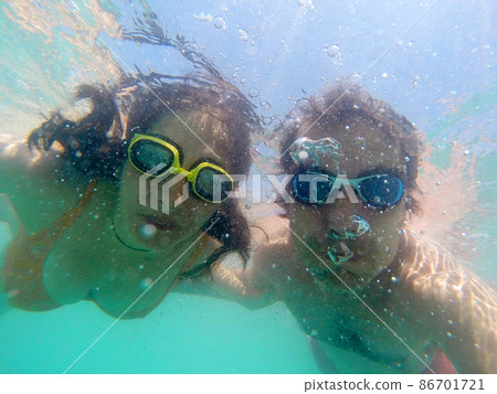 Couple having fun underwater in the sea Couple having fun underwater in the sea 86701721