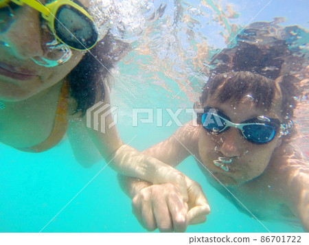 Couple having fun underwater in the sea Couple having fun underwater in the sea 86701722