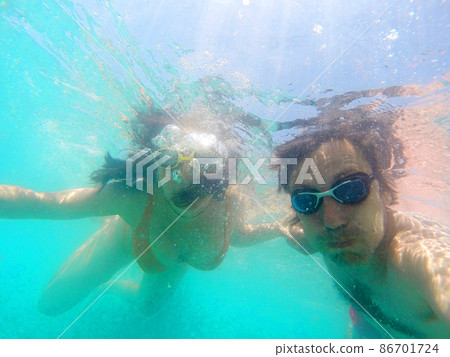 Couple having fun underwater in the sea Couple having fun underwater in the sea 86701724