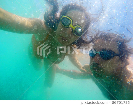 Couple having fun underwater in the sea Couple having fun underwater in the sea 86701725