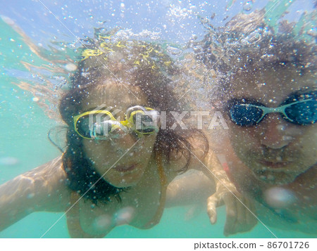 Couple having fun underwater in the sea Couple having fun underwater in the sea 86701726
