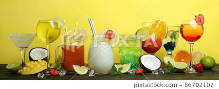 Fresh summer cocktails on wooden table against yellow background 86702102