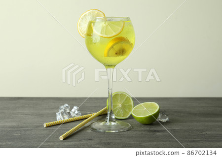 Glass of fresh citrus cocktail on gray table Glass of fresh citrus cocktail on gray table 86702134