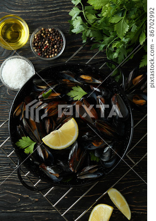 Concept of delicious food with mussels on wooden table Concept of delicious food with mussels on wooden table 86702992