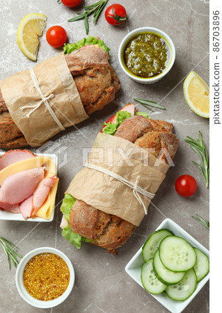 Concept of tasty eating with ciabatta sandwiches on gray textured table 86703896